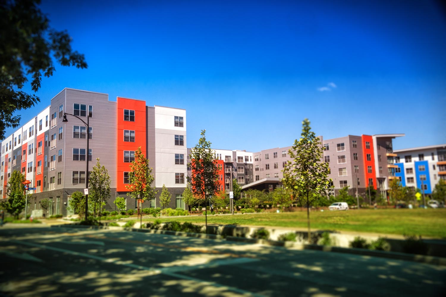 Street scene of condos at Bakery Living made with brightly colored architectural panels of red, blue, and gray. 